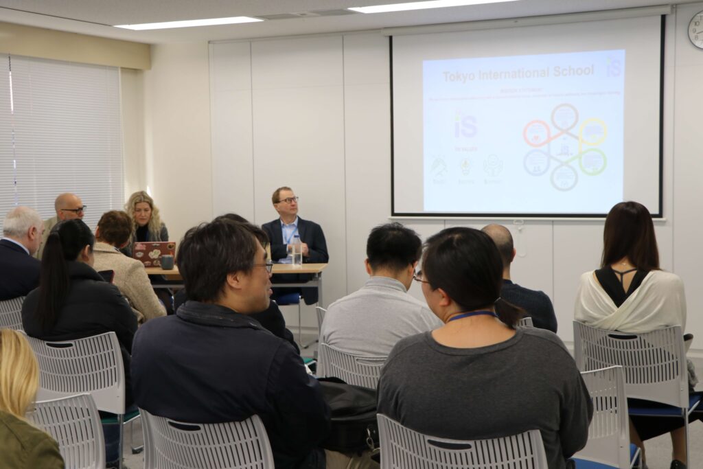 Parents attending a new family orientation at Tokyo International School, engaged as school leaders present from the front of the room.